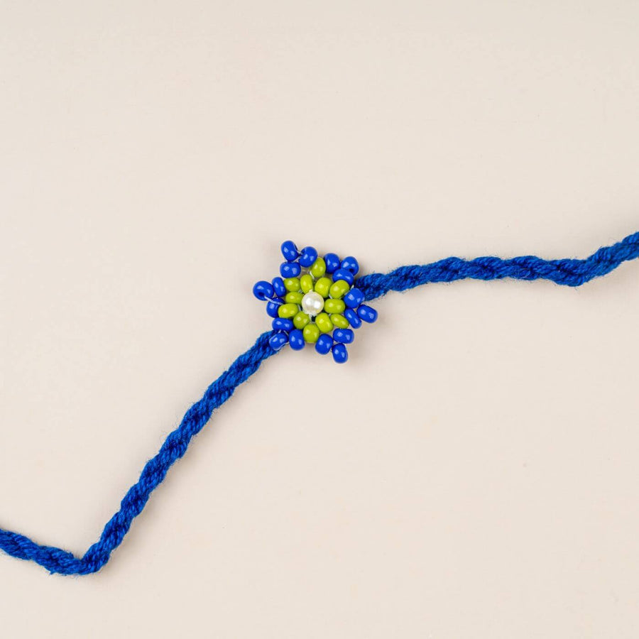 Handcrafted Glass Beads Tara Rakhi 3 - Close-up of blue beaded rakhi