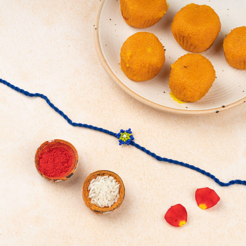 Handcrafted Glass Beads Tara Rakhi 3 - Decorative setup with rakhi and sweets