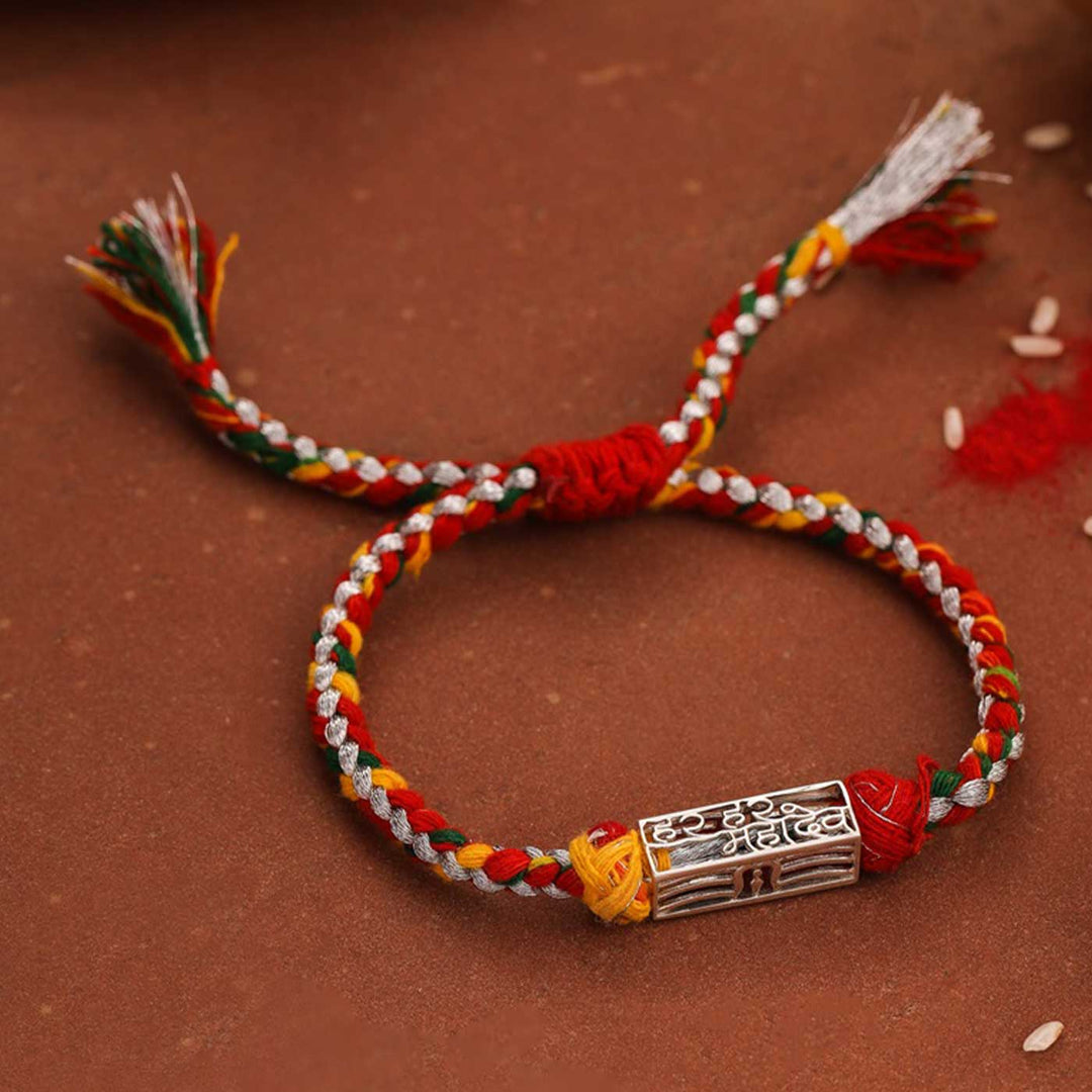Handmade Har Har Mahadev Design Religious Silver Rakhi For Brother - Braided Rakhi on textured surface