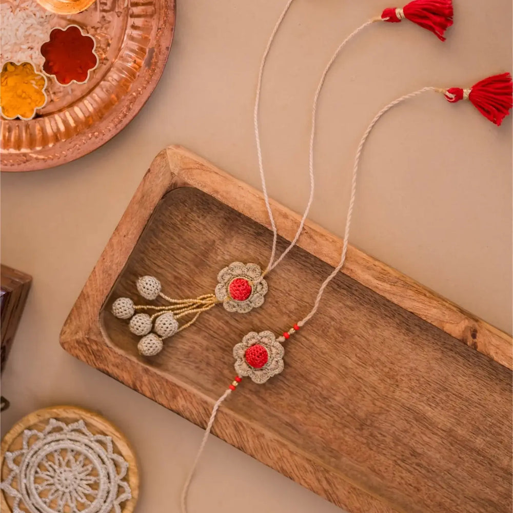 Handmade Crochet Shakti Bhaiya Bhabhi Rakhi With Roli Chawal Set Of 2 - Top View with Decorative Background