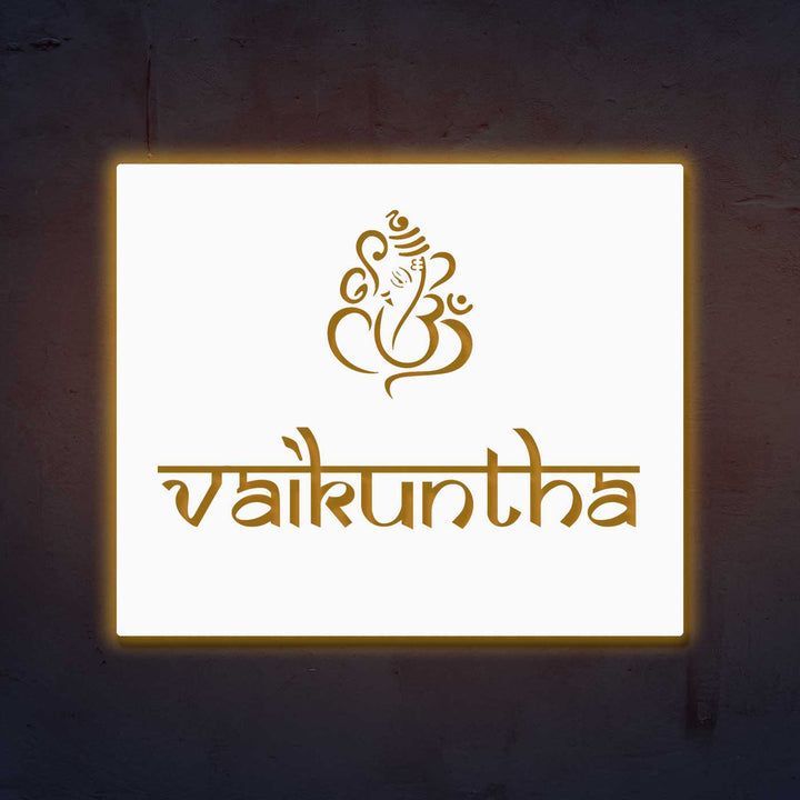 Personalized Laser Cut Ganesha Theme Steel Name Plate - Glowing Front View on Wall