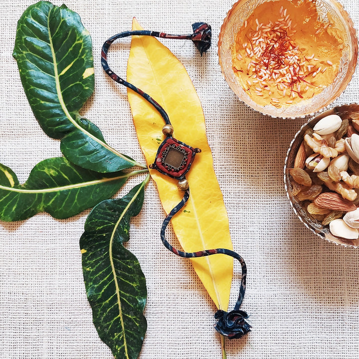 Handmade Dori Work Antique Ajrakh Rakhi With Roli Chawal - Styled with natural elements