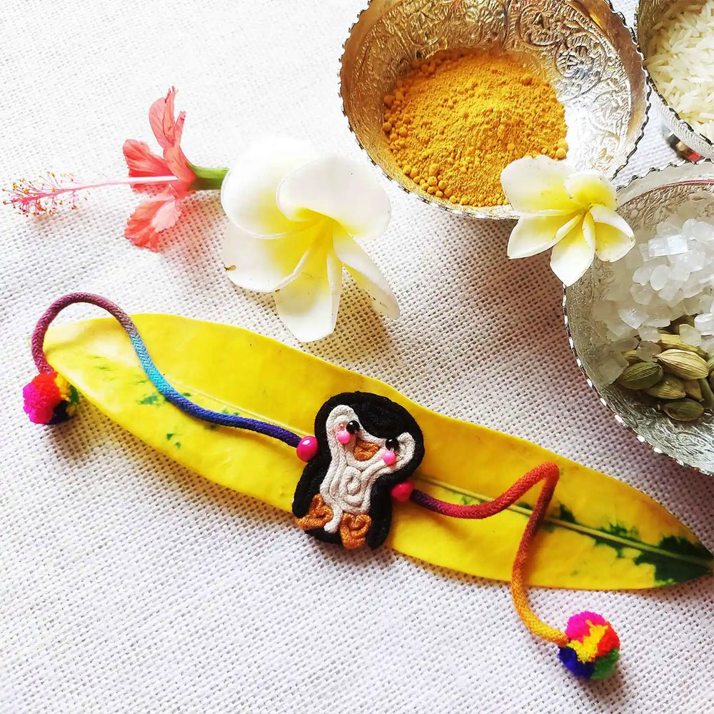 Handmade Dori Work Cute Penguin Kids Rakhi With Roli Chawal - Styled with Decorative Elements