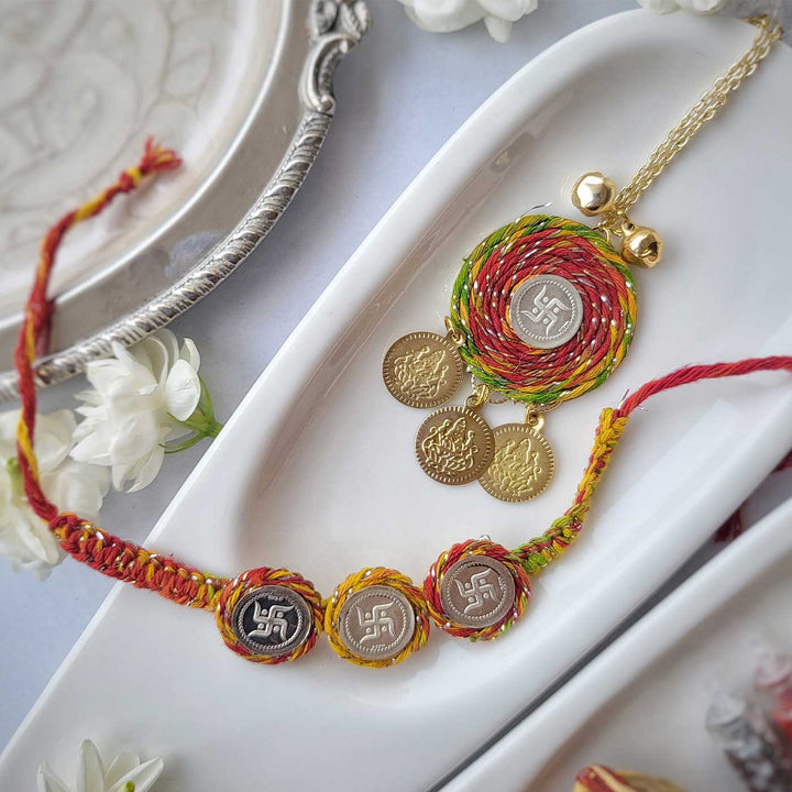Handmade Three Swatik Coin Design Silver Rakhi Hamper With Roli Chawal For Bhaiya And Bhabhi - Bracelet and Pendant Set Front View