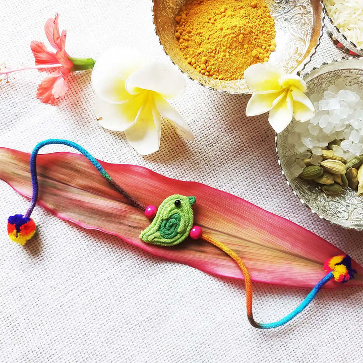 Handmade Dori Work Cute Bird Kids Rakhi With Roli Chawal - Styled with floral and spice decor