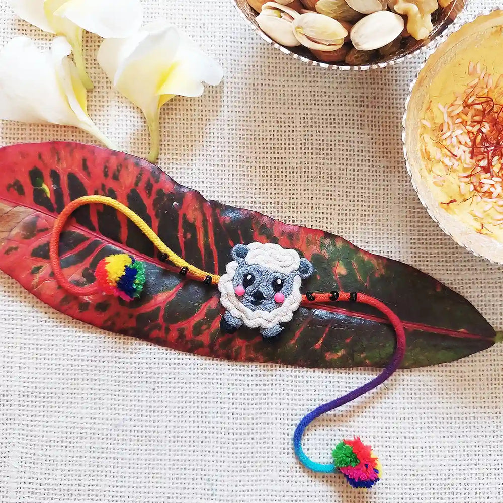 Handmade Dori Work Ba Ba Black Sheep Kids Rakhi With Roli Chawal - Styled on Decorative Leaf