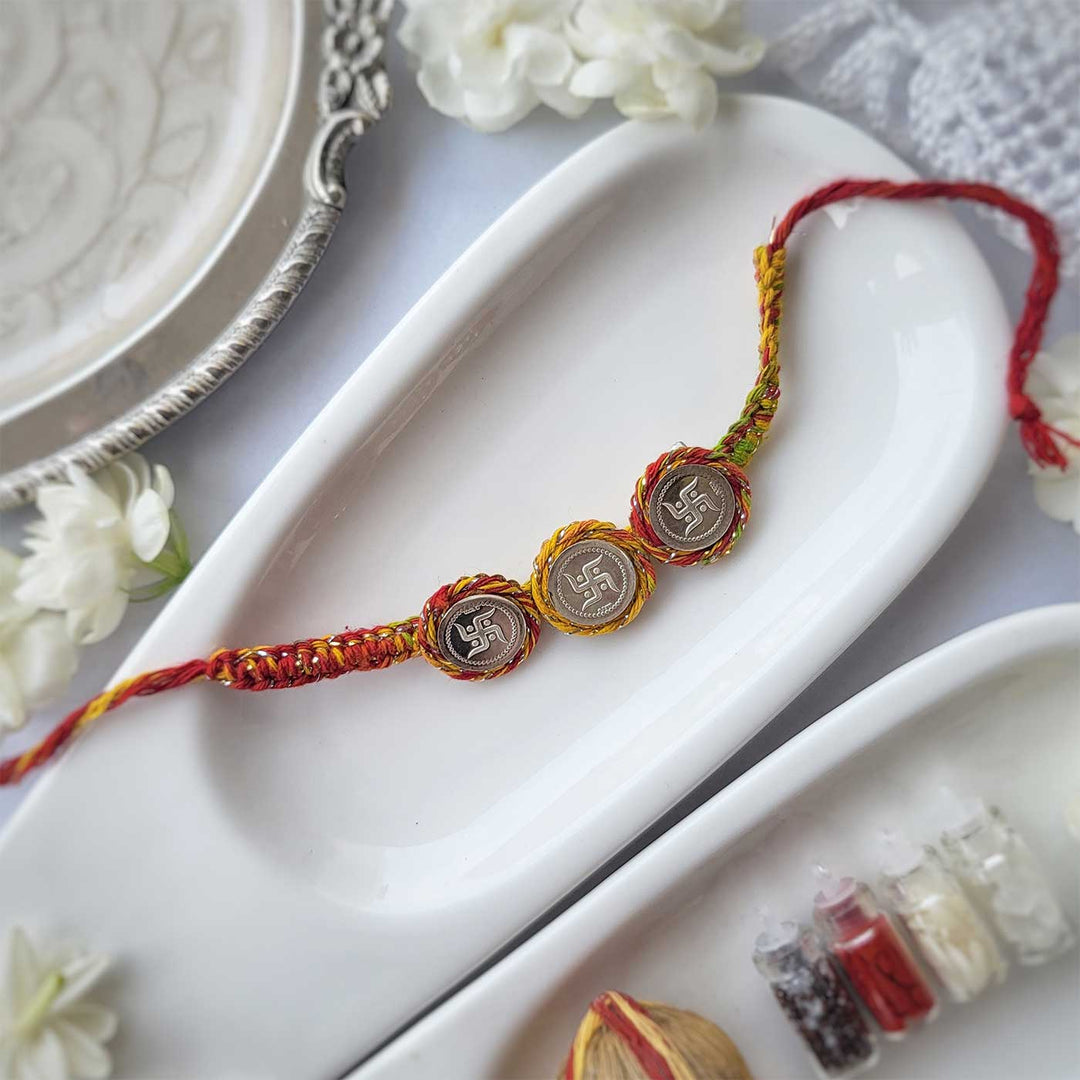 Handmade Three Swatik Coin Design Silver Rakhi Hamper With Roli Chawal For Brother - Full product layout on white tray