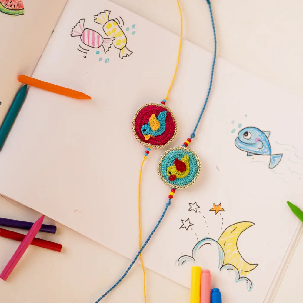 Handmade Crochet Birds Theme Kids Rakhi With Roli Chawal Set Of 2 - Styled with Colored Pencils and Doodles