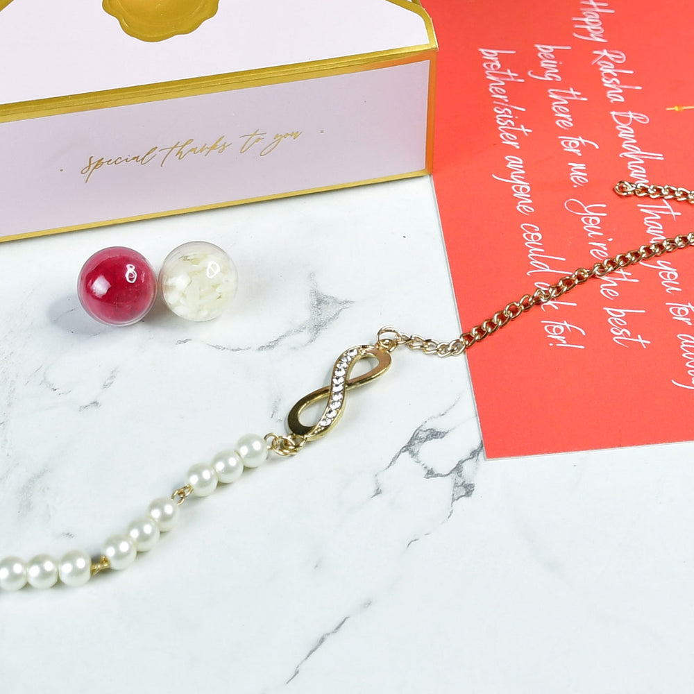 Beaded Infinity Pearl And Stone Bracelet Rakhi Hamper With Chocolates And Roli Chawal For Brother Customizable Options Includes Up To 7 Goodies - Rakhi arrangement with packaging