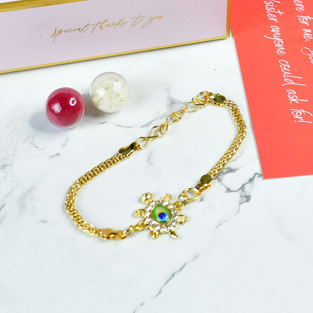 Green Turtle Pearl And Stone Bracelet Rakhi Hamper With Chocolates And Roli Chawal For Brother Customizable Options Includes Up To 7 Goodies - Bracelet Styled with Props