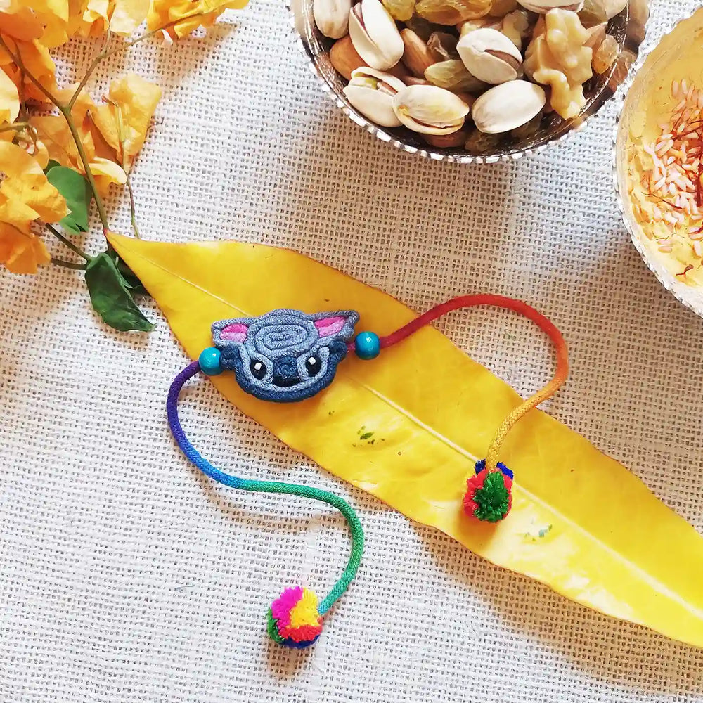 Handmade Dori Work Baby Koala Kids Rakhi With Roli Chawal - Styled Flat Lay
