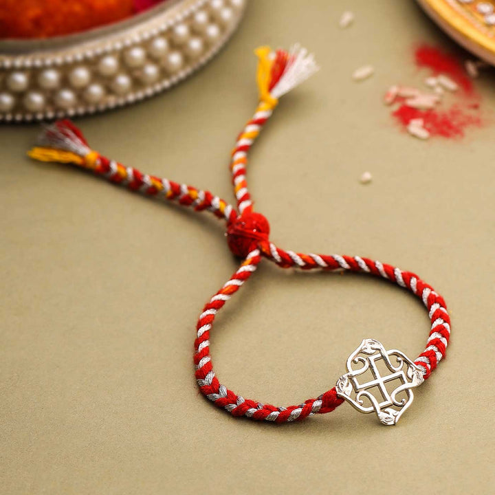 Handmade Swastik Design Silver Rakhi For Brother - Front View with Background Props