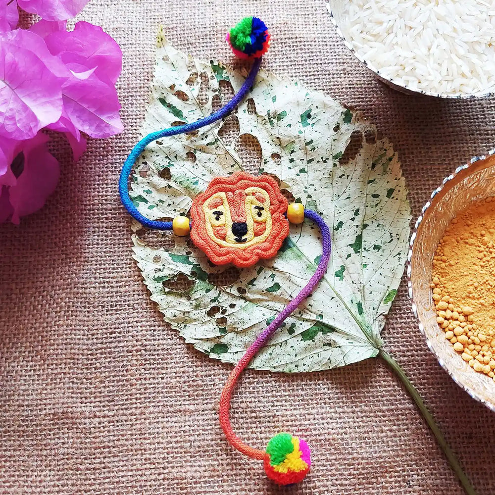 Handmade Dori Work Cute Lion Kids Rakhi With Roli Chawal - Styled Flat Lay with Props