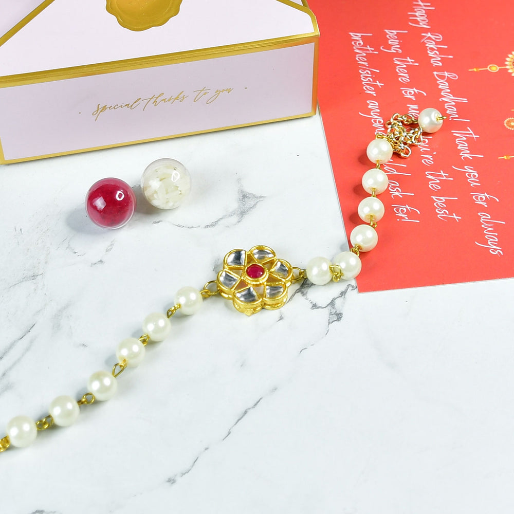 Beaded Pearl And Stone Bracelet Rakhi Hamper With Chocolates And Roli Chawal For Brother Customizable Options Includes Up To 7 Goodies - Flat lay with Rakhi and pearls