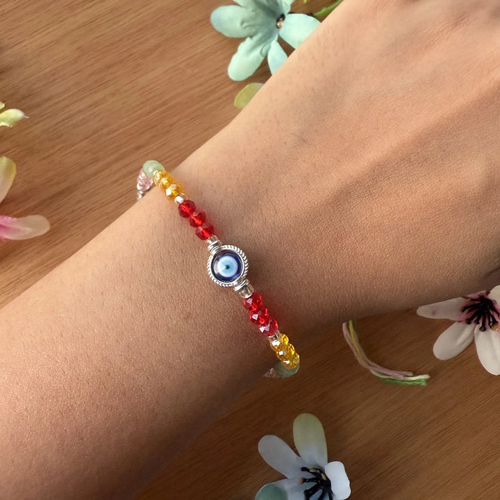 Handmade Round Beaded Evil Eye Rakhi With Roli Chawal - Worn on Wrist with Flowers
