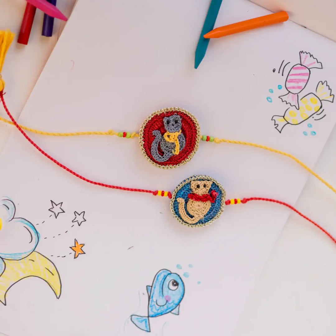 Handmade Crochet Kitten Theme Kids Rakhi With Roli Chawal Set Of 2 - Styled on Art Paper Background