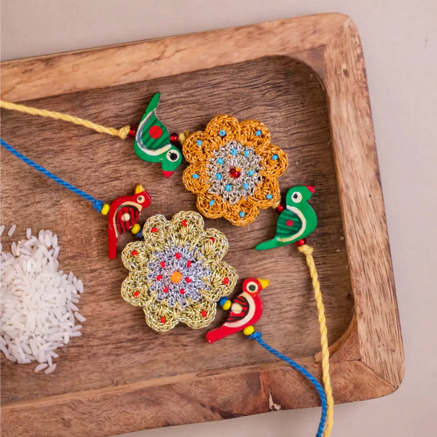 Handmade Crochet Flower And Birds Rakhi With Roli Chawal Set Of 2 - Close-up of decorative strings