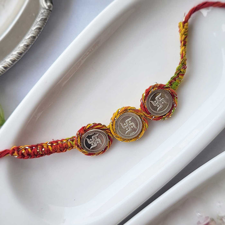 Handmade Three Swatik Coin Design Silver Rakhi Hamper With Roli Chawal For Bhaiya And Bhabhi - Bracelet Front View