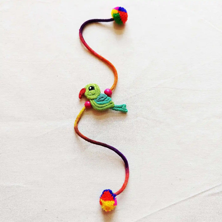 Handmade Dori Work Cute Parrot Kids Rakhi With Roli Chawal - Full Product Layout on Surface