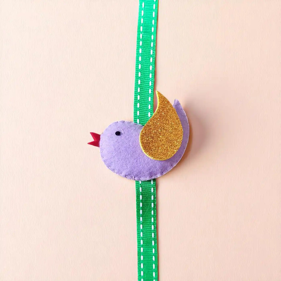 Handmade Bird Theme Felt Kids Rakhi With Roli Chawal - Side view of purple bird accessory