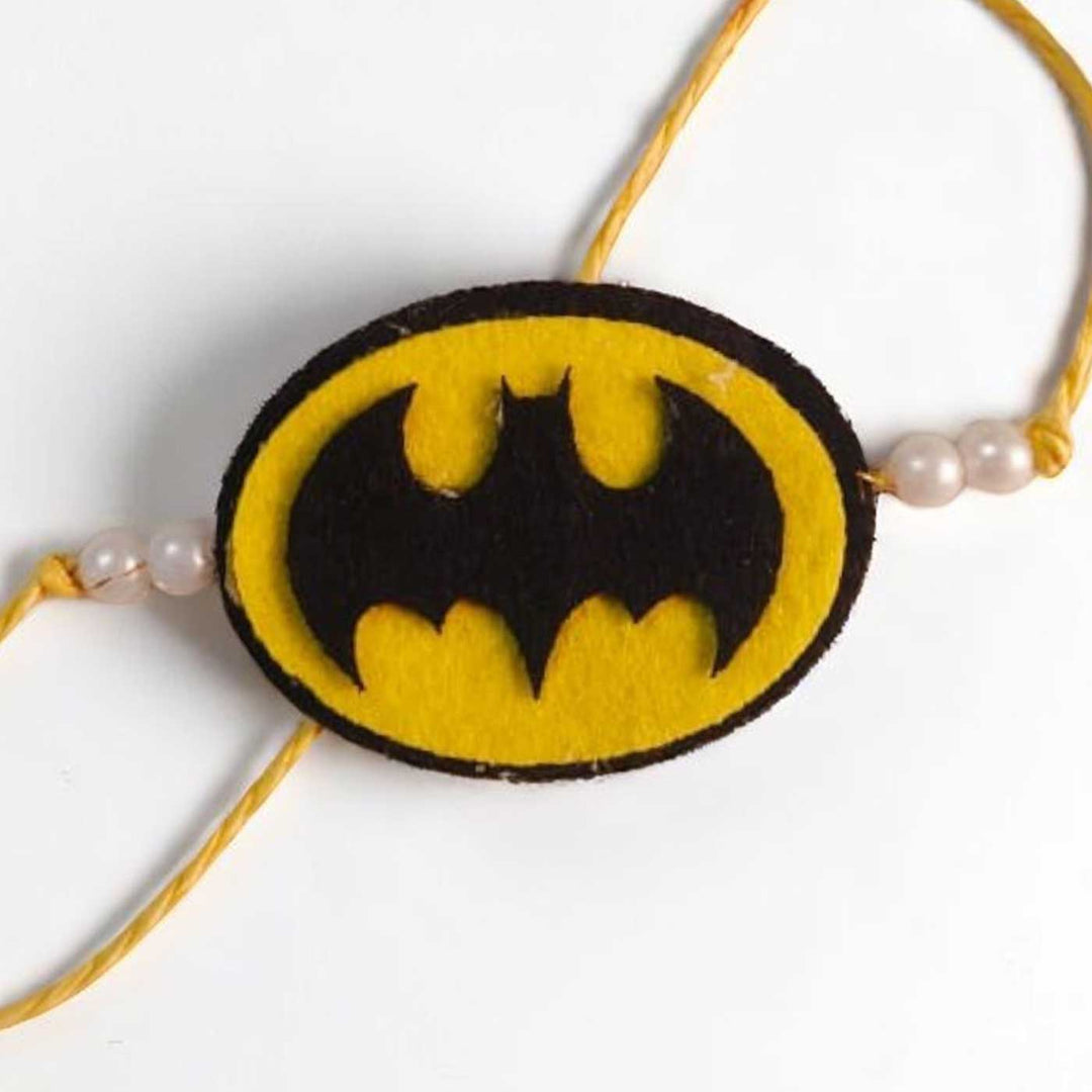 Handmade Beaded Batman Theme Pom Pom Felt Rakhi With Roli Chawal For Kids - Close-up of Emblem