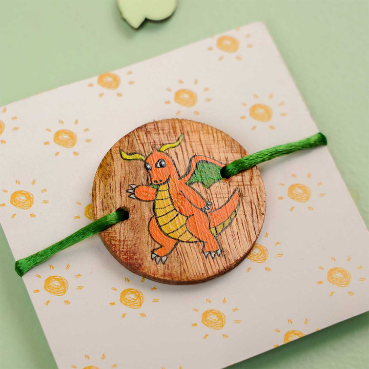Personalized Hand Painted Dragonite Wooden Rakhi With Roli Chawal - Angled Close-up on Cardstock
