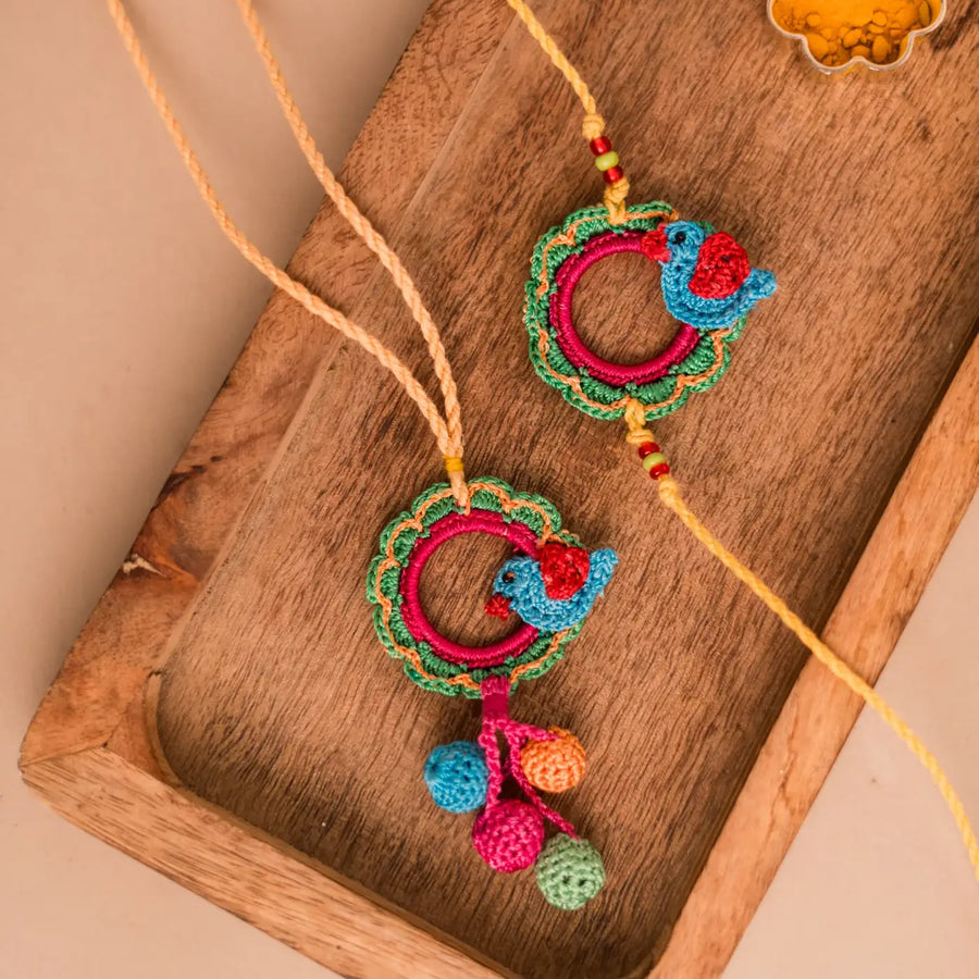 Handmade Crochet Sonchidiya Bhaiya Bhabhi Rakhi With Roli Chawal Set Of 2 - Front View on Wood Tray