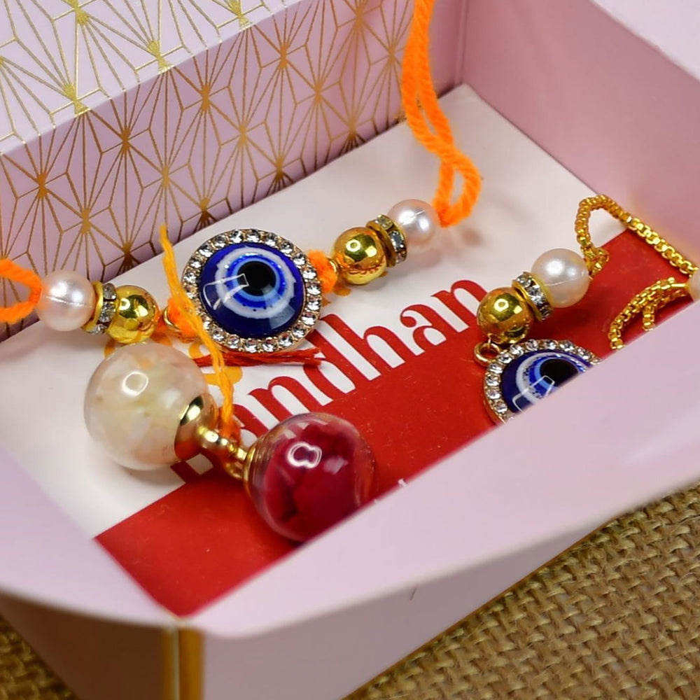 Beaded Blue Evil Eye Rakhi Hamper With Chocolates And Roli Chawal For Bhaiya And Bhabhi Customizable Options Includes Up To 7 Goodies - In packaging with text visible