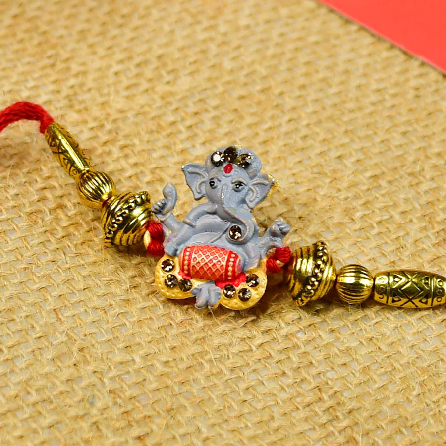 Beaded Ganesha Rakhi With Chocolates And Roli Chawal For Brother Customizable Options Includes Up To 7 Goodies - Close-up of decorated rakhi