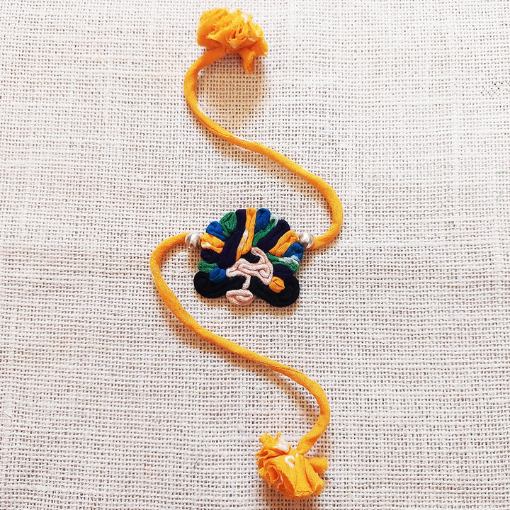 Handmade Dori Work Ethnic Rabari Rakhi With Roli Chawal - Flat Lay Orange Thread Bracelet