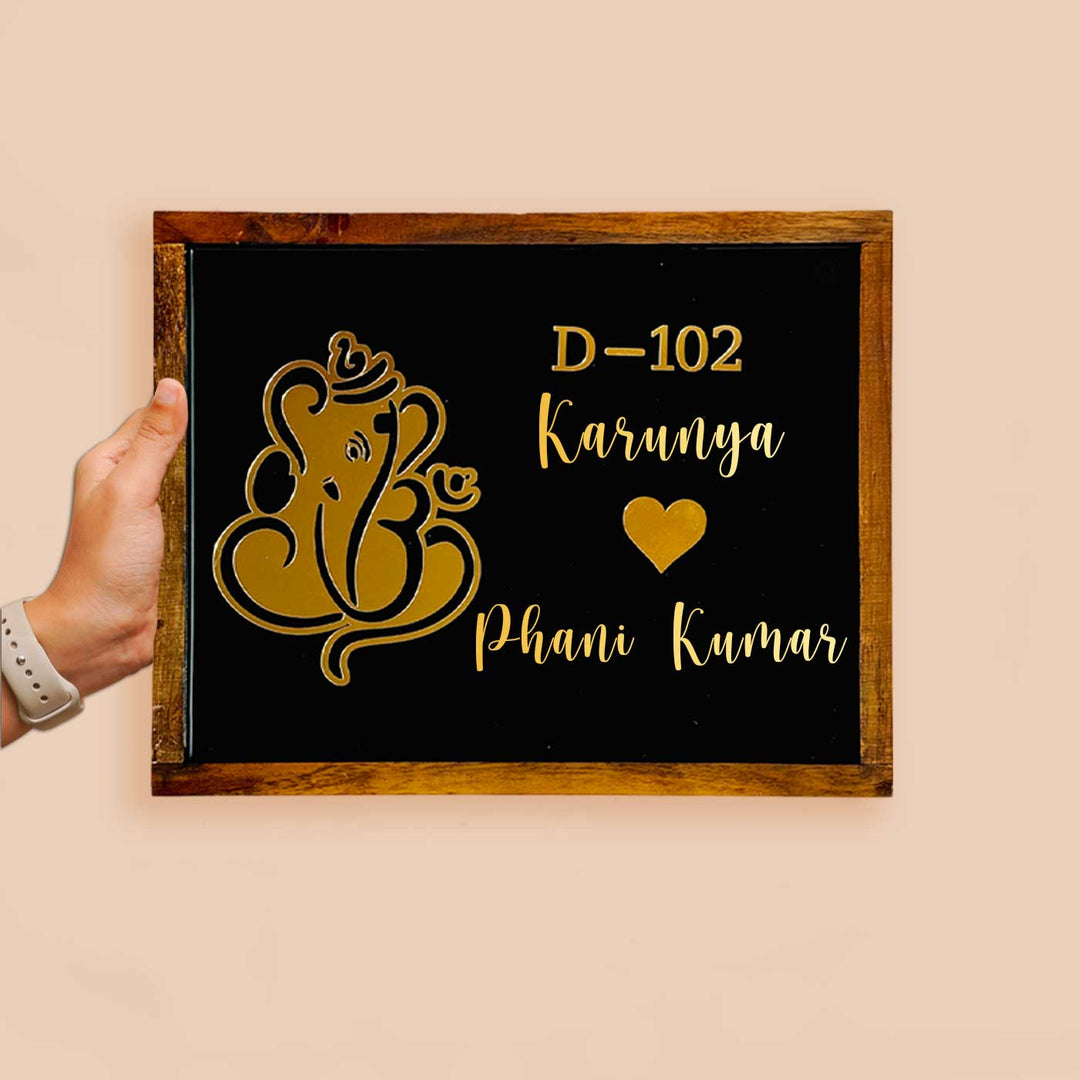 Personalized Ganesha Theme Resin Name Plate With Teak Wood Border For Couples - Front View Held by Hand