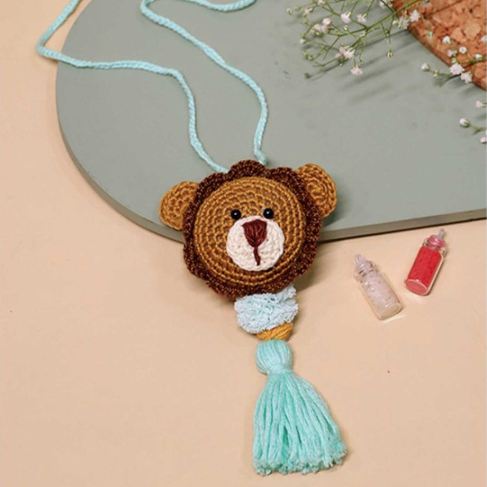 Handmade Crochet Lion Cub Kids Lumba Rakhi With Roli Chawal - Front View with Background Props