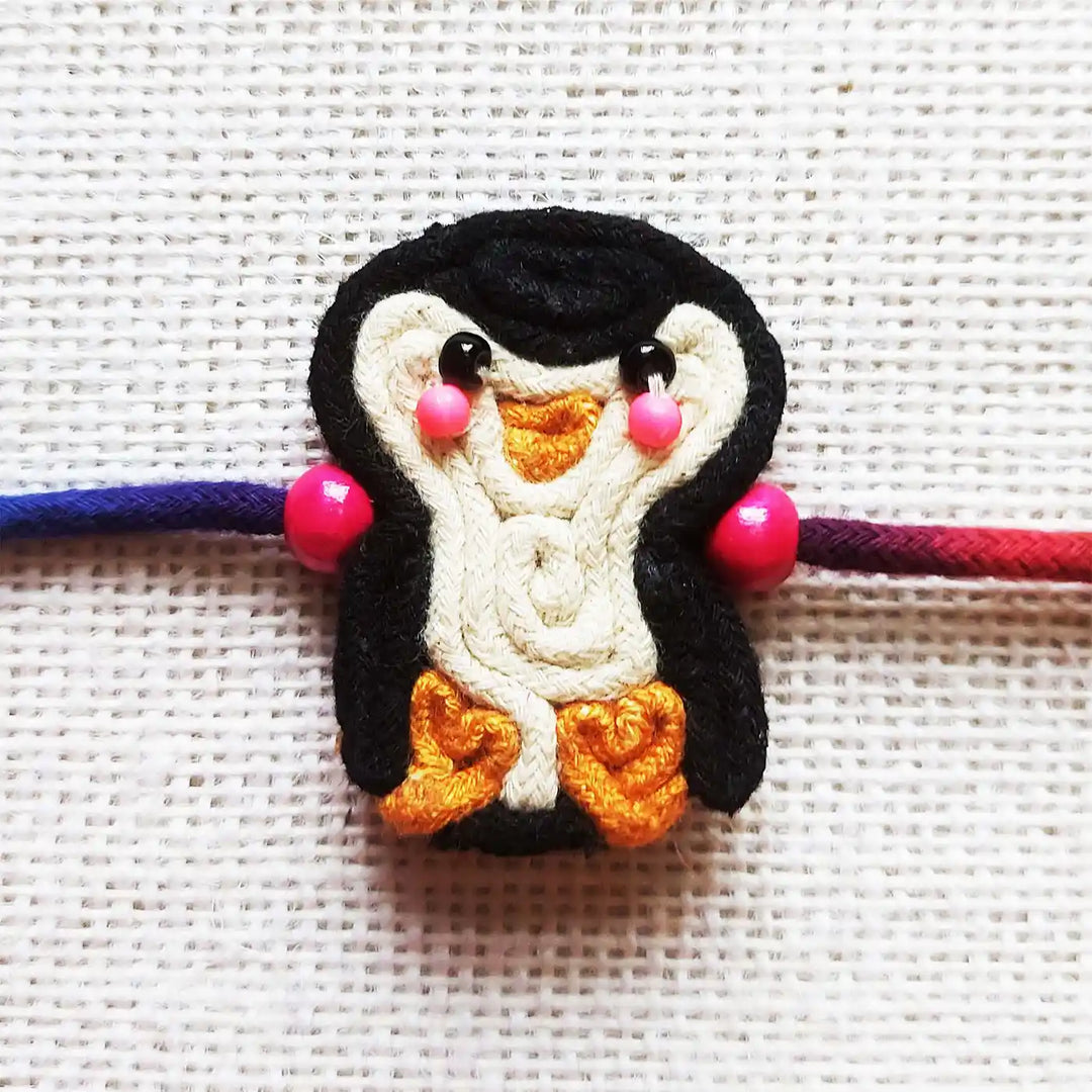 Handmade Dori Work Cute Penguin Kids Rakhi With Roli Chawal - Close-up of Penguin Charm
