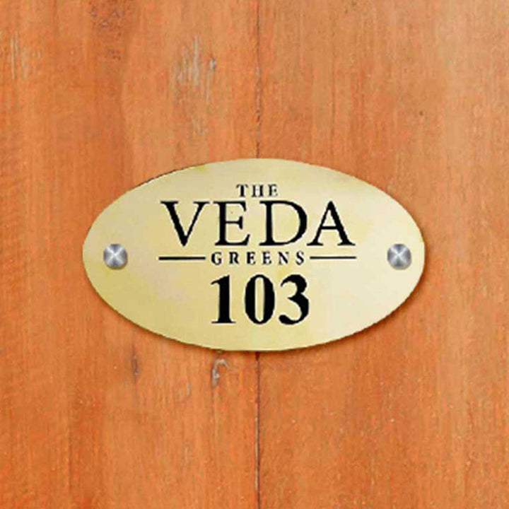 Personalized Waterproof Oval Golden Metal Name Plate - Mounted on Wooden Surface Front View