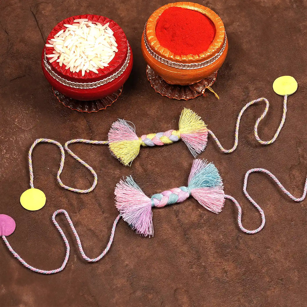 Handmade Braided Candy Rakhi With Roli Chawal Set Of 2 - Flat Lay with Decorative Containers and Dots