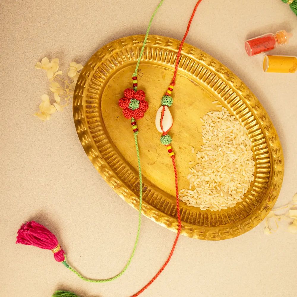 Handmade Crochet Phool Kaudi Rakhi With Roli Chawal Set Of 2 - Top view with decorative items