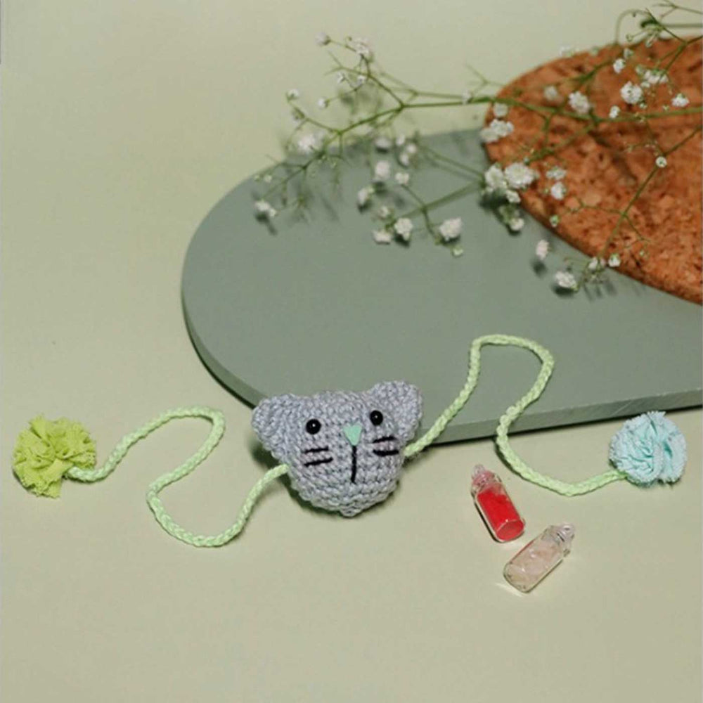 Handmade Crochet Kitty Kisses Kids Lumba Rakhi With Roli Chawal - Full view on flat surface