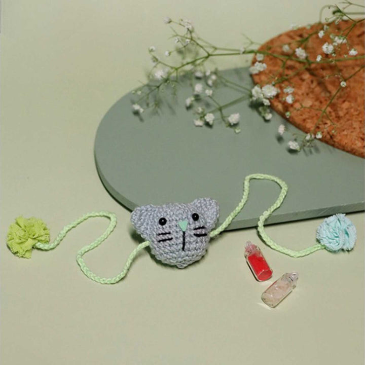 Handmade Crochet Kitty Kisses Kids Lumba Rakhi With Roli Chawal - Full view on flat surface