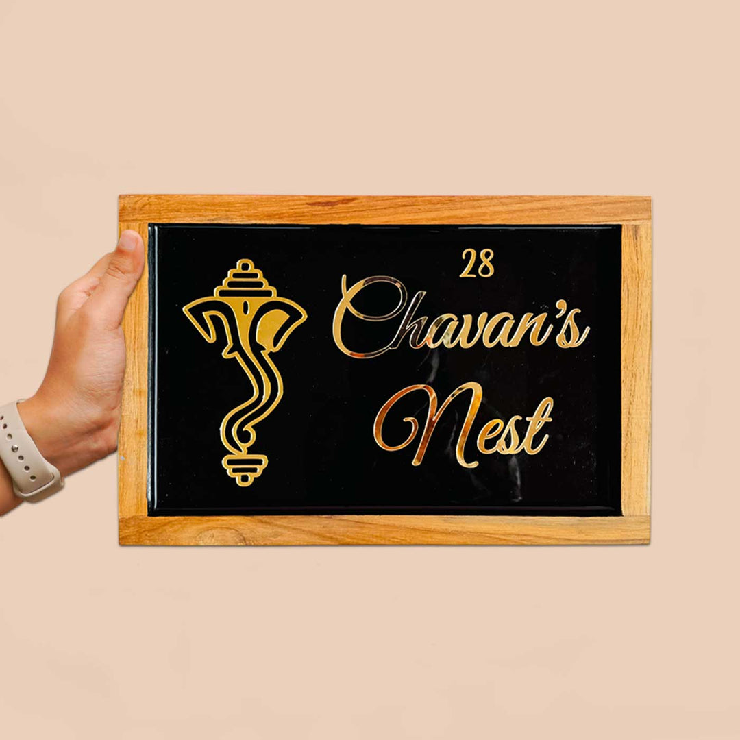 Personalized Ganesha Face Theme Resin Name Plate With Teak Wood Border For Couples - Front View Held in Hand