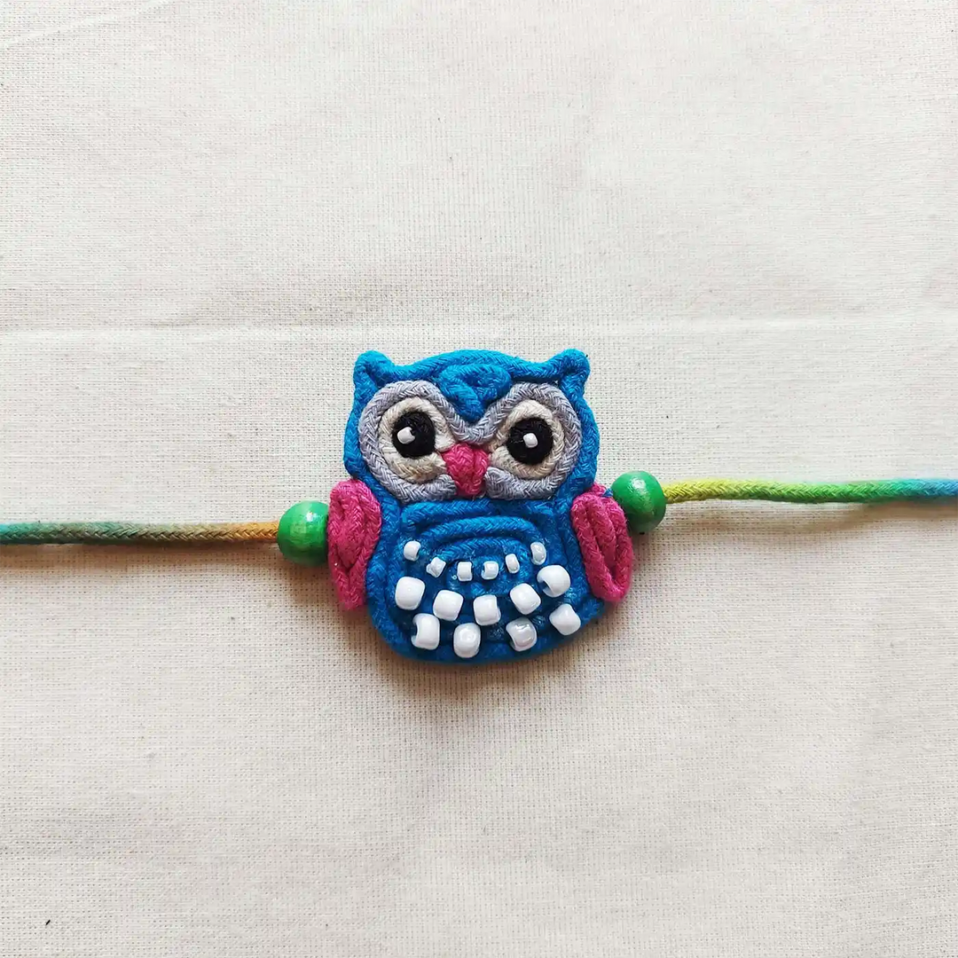 Handmade Dori Work Beaded Blue Owl Kids Rakhi With Roli Chawal - Close-up Front View