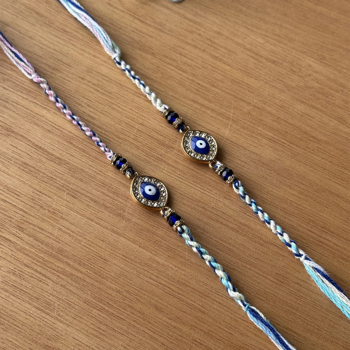 Handmade Stone Embedded Evil Eye Rakhi With Roli Chawal - Close-up of Dual Bracelets