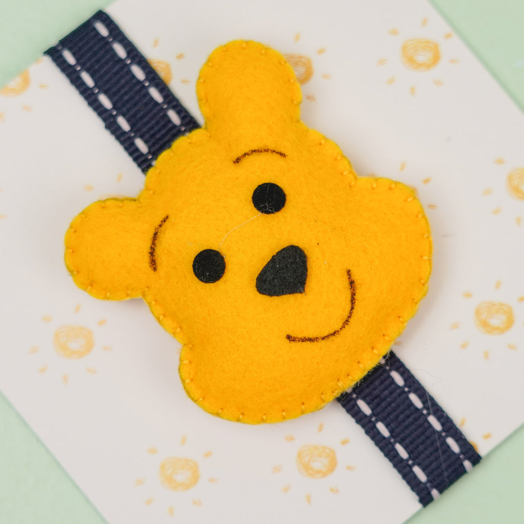 Handmade Pooh Theme Felt Kids Rakhi With Roli Chawal - Close-up of Face Detail
