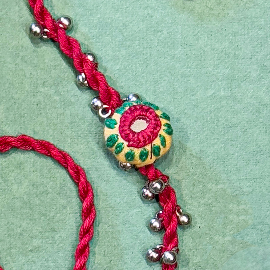 Handmade Reusable Red Potli And Jhumki Rakhi For Brother - Close-up of Thread and Beads