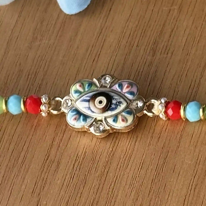 Handmade Multicolor Beaded Evil Eye Rakhi With Roli Chawal - Macro detail of bracelet centerpiece