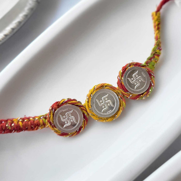 Handmade Three Swatik Coin Design Silver Rakhi Hamper With Roli Chawal For Bhaiya And Bhabhi - Bracelet Detail Close-up