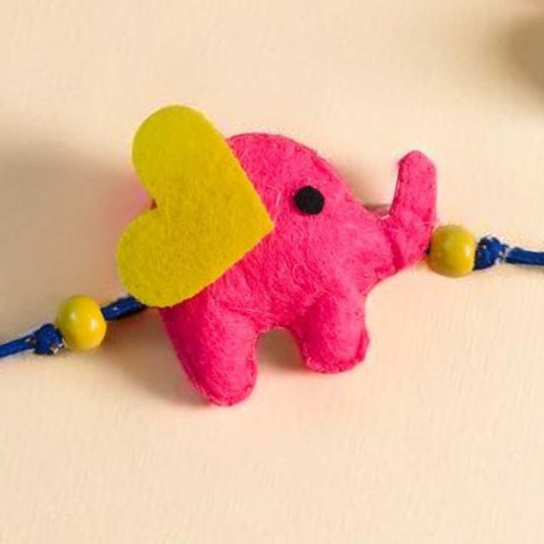 Customized Handmade Beaded Elephant Theme Pom Pom Felt Rakhi With Roli Chawal For Kids - Close-up of Pink Elephant Charm
