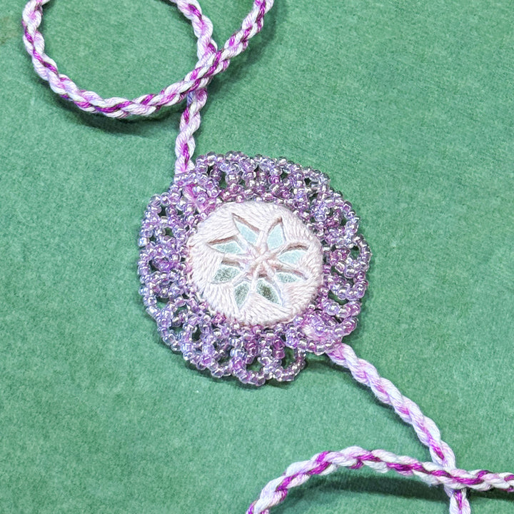 Handmade Reusable Lavender Mirror And Jhumki Rakhi For Bhaiya And Bhabhi - Close-up of Detailed Beaded Pendant
