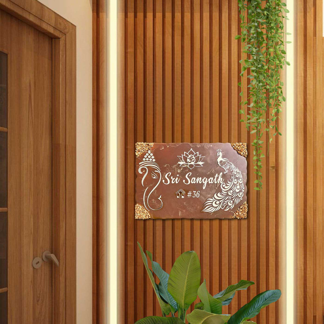 Personalized Metallic Brown Ganesha And Peacock Theme Resin Name Plate - Mounted on Entryway Wall with Plants