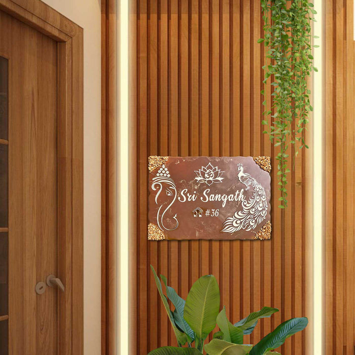 Personalized Metallic Brown Ganesha And Peacock Theme Resin Name Plate - Mounted on Entryway Wall with Plants