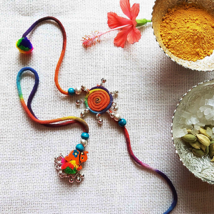 Handmade Dori Work Elephant And Ghungroo Bhaiya Bhabhi Rakhi With Roli Chawal Set Of 2 - Styled product with decorative bowls